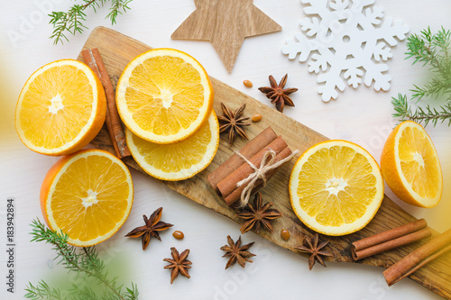 oranges with anisestars, cinnamon sticks and juniper branch photo