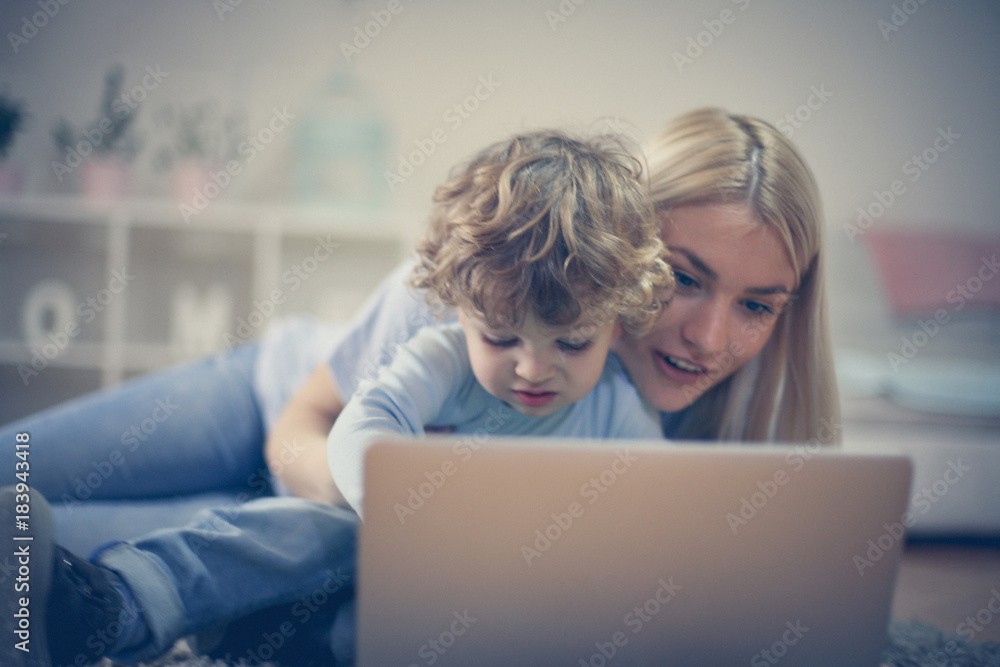 Mother and son play games on laptop.