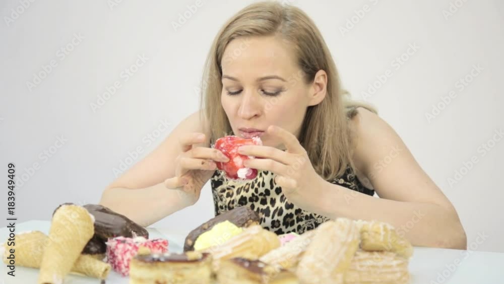 Young woman eating cupcakes with pleasure after a diet Young woman eating cupcakes with pleasure after a diet