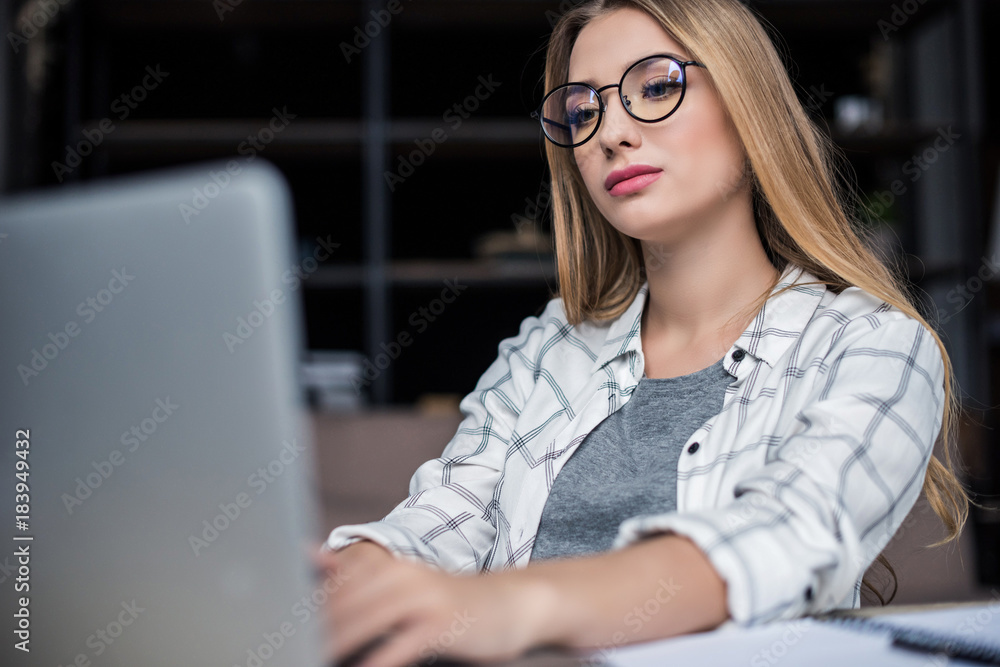 focused young businesswoman working with laptop at workplace focused young businesswoman working with laptop at workplace