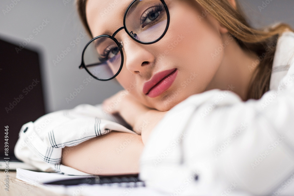 Φωτογραφία beautiful young exhausted woman lying on table and looking at camera