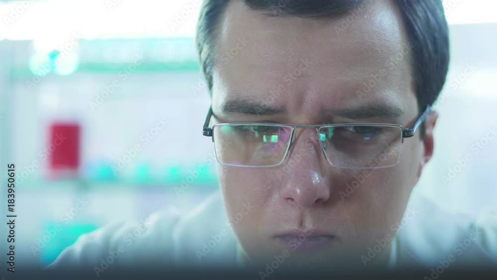 Serious doctor working at computer in laboratory Serious doctor working at computer in laboratory