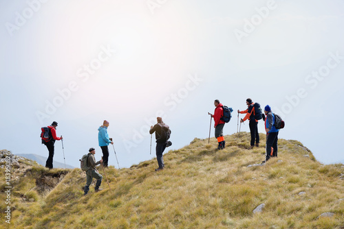 Group of People of different age and ethnicity walking up on Mountain Trail during Hike