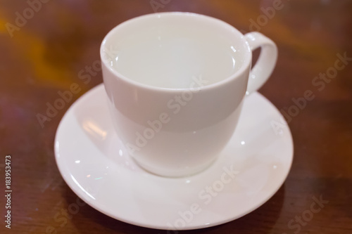 White cup with clean water on a saucer