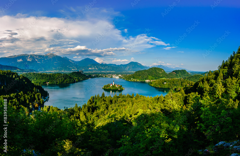 Colorful summer scene on the Bled lake with the famous Pilgrimage Church of the Assumption of Maria and Bled Castle and Julian Alps at background