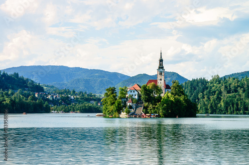 Colorful summer scene on the Bled lake with the famous Pilgrimage Church of the Assumption of Maria and Bled Castle and Julian Alps at background