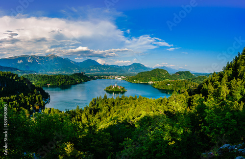 Colorful summer scene on the Bled lake with the famous Pilgrimage Church of the Assumption of Maria and Bled Castle and Julian Alps at background