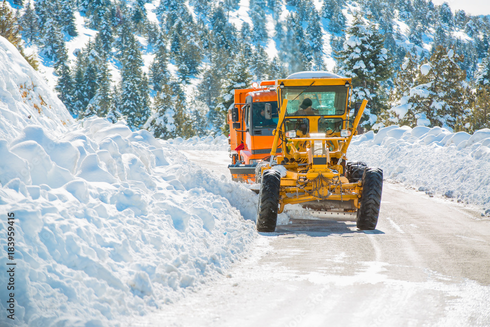 The bulldozer cleans snow on road The bulldozer cleans snow on road