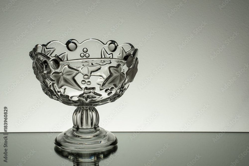Crystal glass illuminated on mirror and black background Crystal glass illuminated on mirror and black background