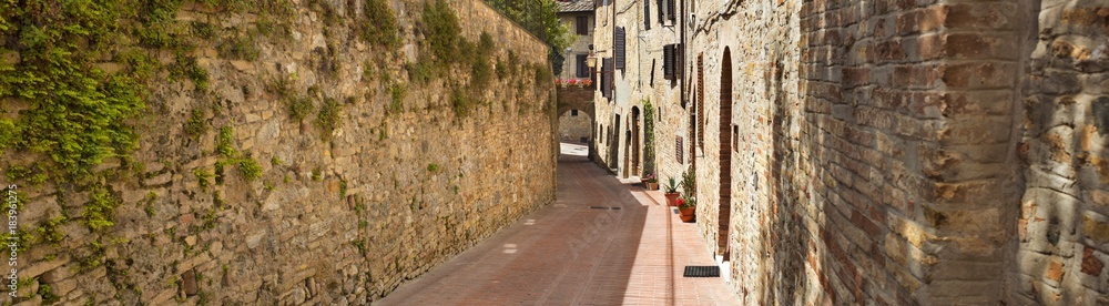 wide panorama on the street with old walls in Tuscany in Italy
