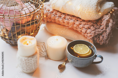 Cozy winter morning at home. Hot tea with lemon, knitted sweaters and modern metallic interior details. Still life composition, danish hygge concept photo