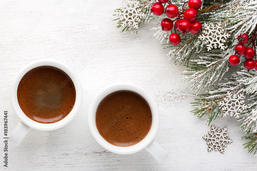 Two cups of coffee and fir branch with Christmas decorations on old wooden shabby background. Two cups of coffee and fir branch with Christmas decorations on old wooden shabby background.