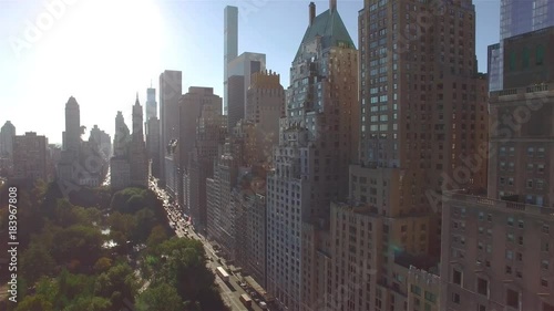 Aerial real time shot, camera is flying above Central Park and approaching to the intersection of West 95th Street and Fifth Avenue in New York. Camera is slowly moving forward.