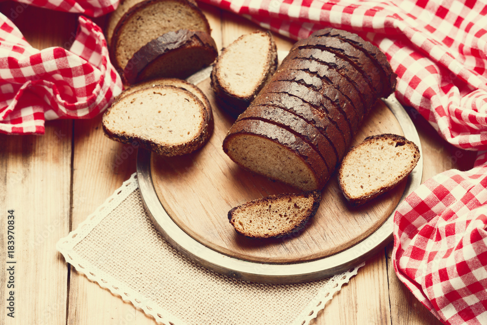 Sliced rye bread on a cutting board and tablecloth Sliced rye bread on a cutting board and tablecloth