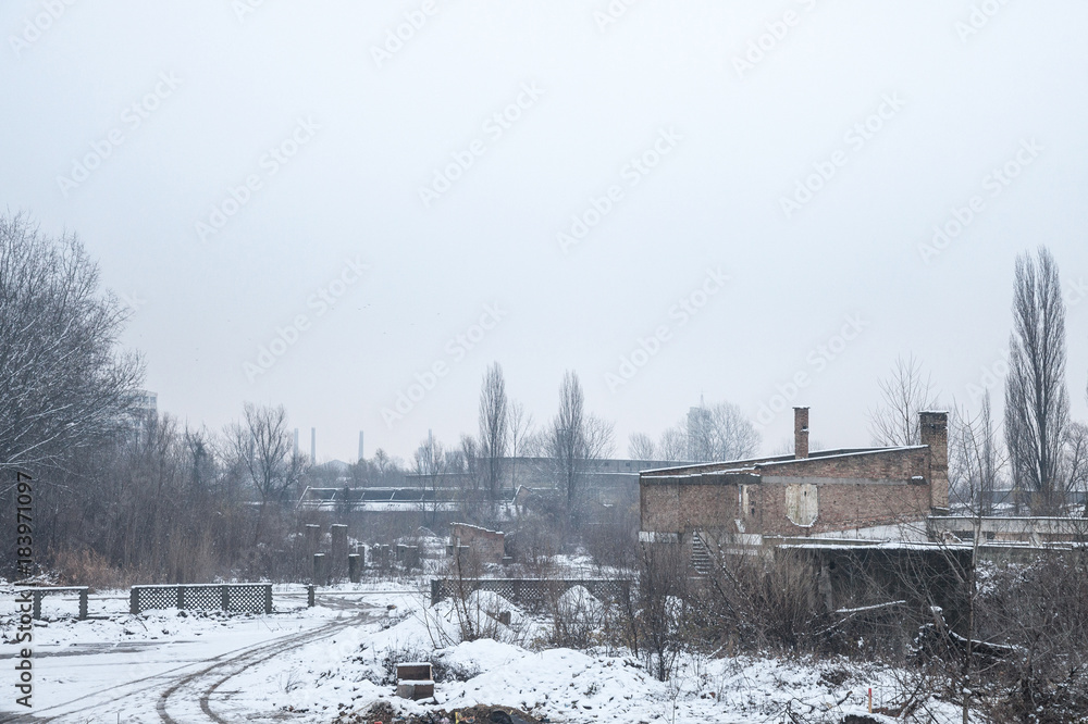 Abandoned factories and warehouses under the snow in Eastern Europe, in Pancevo, Serbia, former Yugoslavia, during a cold winter afternoon. Abandoned factories and warehouses under the snow in Eastern Europe, in Pancevo, Serbia, former Yugoslavia, during a cold winter afternoon.