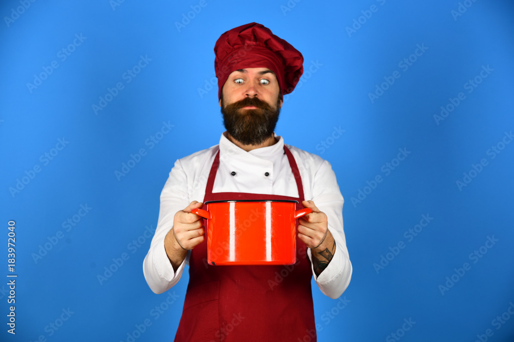 Obraz premium Chef holding a pot and looking at it with surprise
