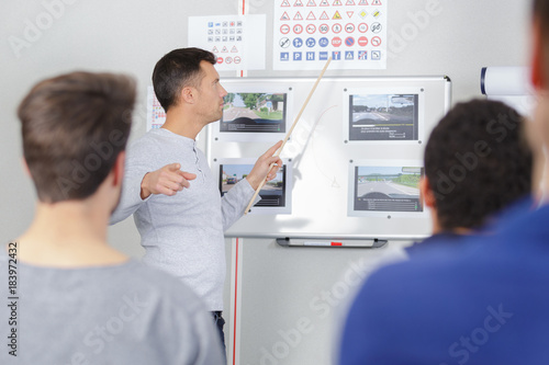 Fotografija driving instructor in his class teaching trafic code to students