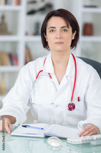 portrait of young female doctor in her office photo