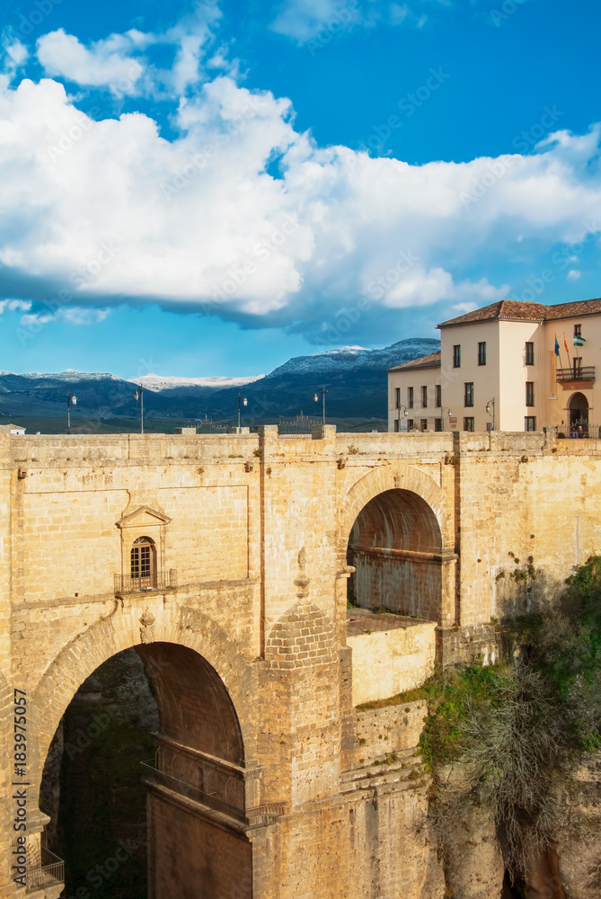 RONDA, SPAIN - FEBRUARY 04, 2014: A view to famous New Bridge (Puente Nuevo), houses standing near the bridge and mountains in Ronda, one of the most famous white villages (pueblos blancos) in Malag