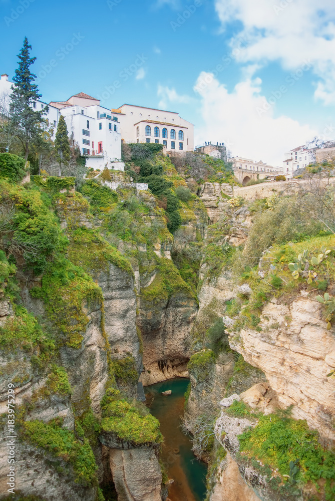 A view to Guadalevin river at El Tajo Gorge Canyon and traditional andalusian houses at the cliff in Ronda, a famous white village (pueblo blanco) in Malaga province, Andalusia, Spain.
