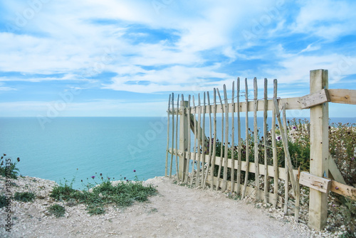 An old wooden fence at the edge of chalk cliffs  coastal erosion at Seven Sisters country park near Easbourne  East Sussex  England.