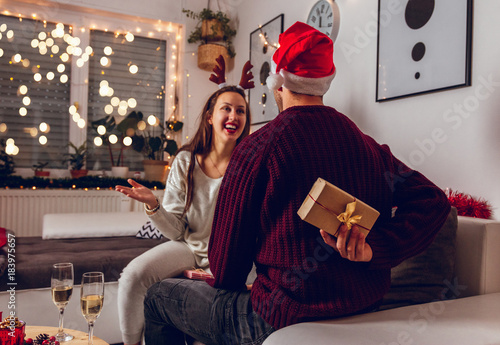Merry Christmas and Happy New Year! Cute, young couple exchanging Christmas presents