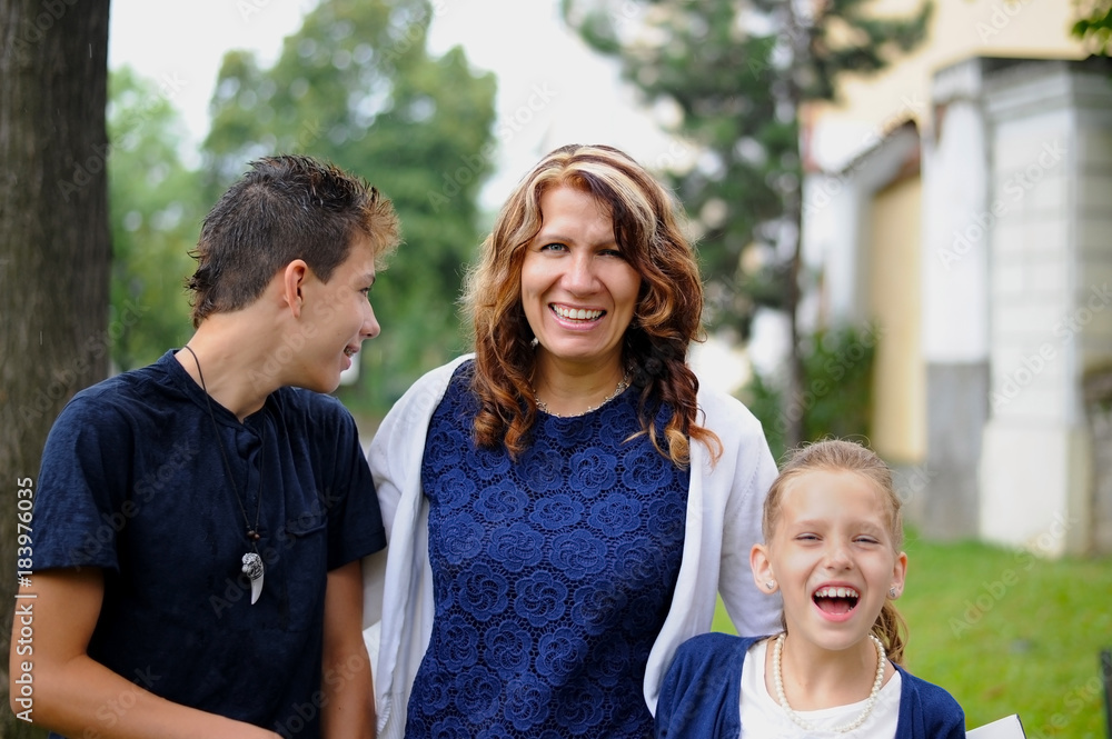 Fototapeta premium Mom is having a rest in the city with her children. They are happy and laugh