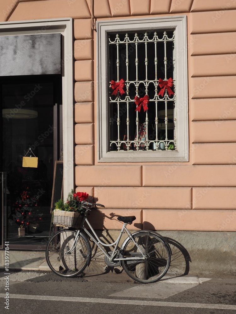 Italian street,  a bike next to a store.