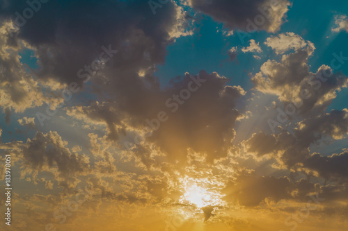 Bright dark and orange clouds on the  blue sky at sunset or sunrise photo