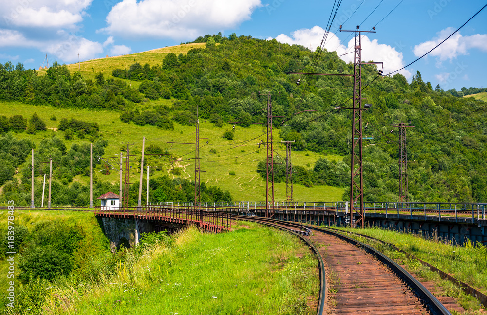 Naklejka premium railroad viaduct through forested hills in summer. lovely transportation scenery in Carpathian mountains, Skotars'ke, Ukraine
