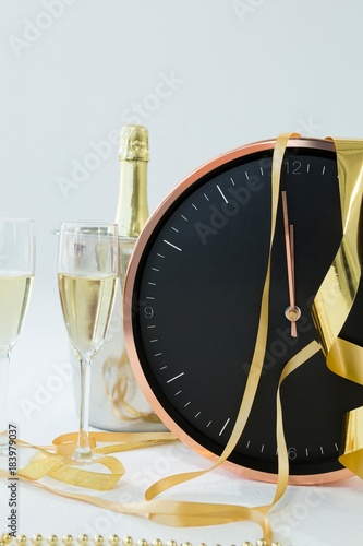 Champagne with clock and glass on white background © WavebreakMediaMicro
