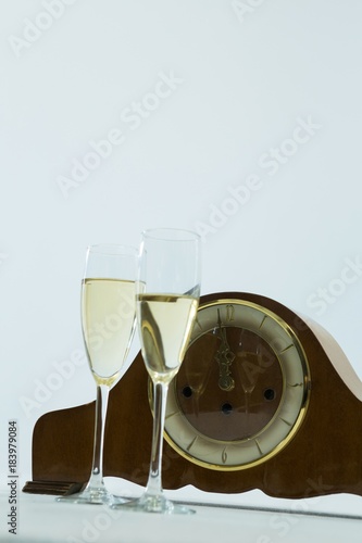 Champagne glass and clock on white background © WavebreakMediaMicro