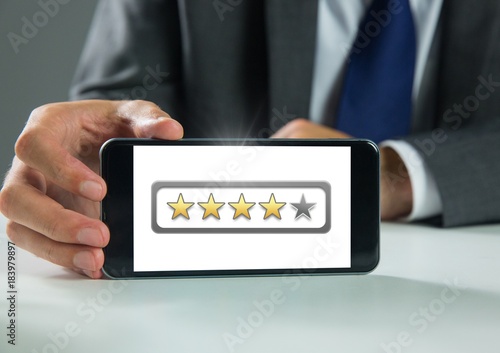 Hand holding phone with star ratings review