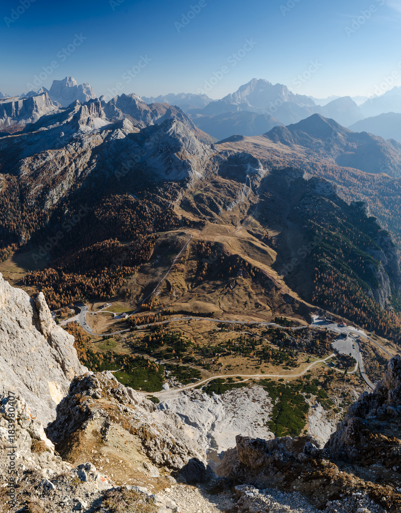 Aerial panoramic view of rocky mountains and mountain road in the valley