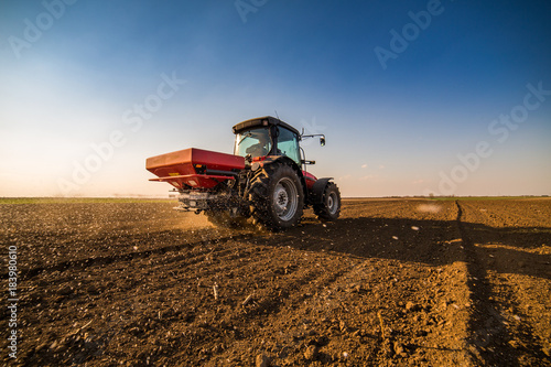 Farmer fertilizing arable land with nitrogen, phosphorus, potassium fertilizer photo