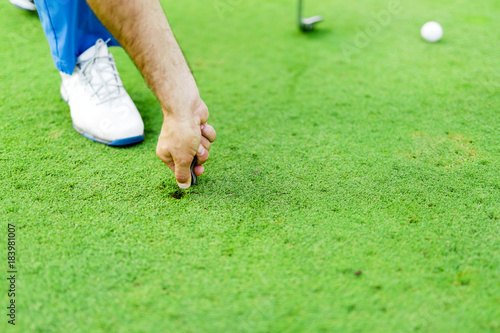 Fotografi Golf player repairing divot