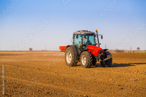 Farmer fertilizing arable land with nitrogen  phosphorus  potassium fertilizer