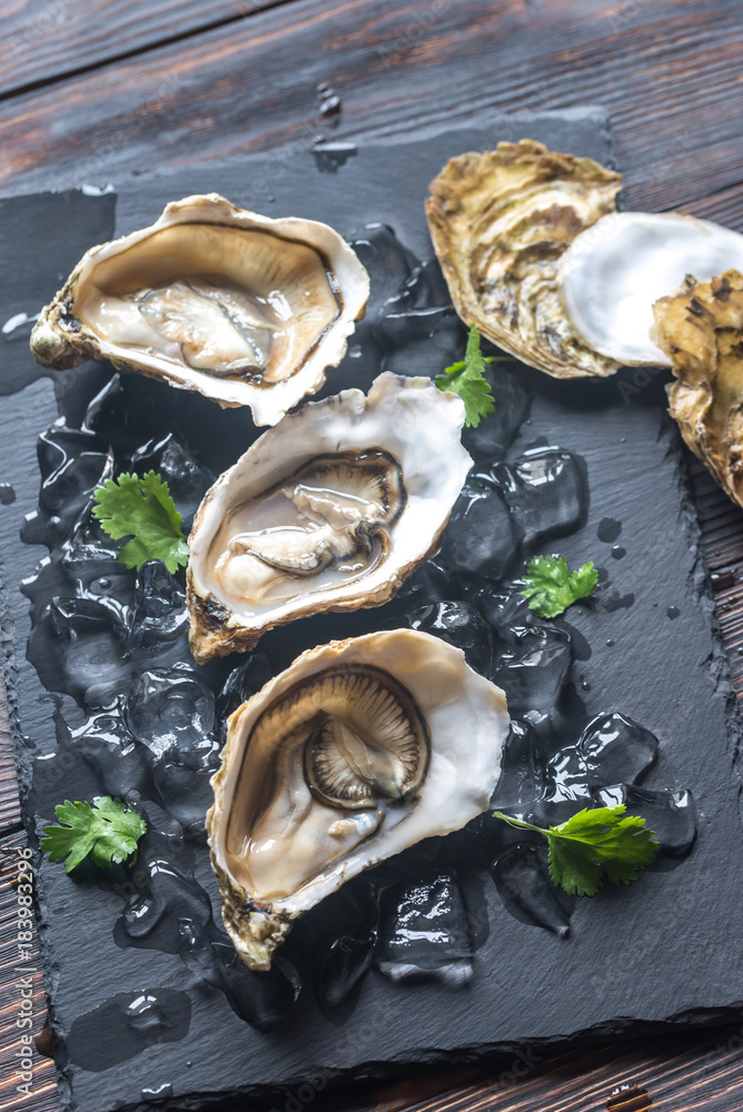 Raw oysters on the black stone board
