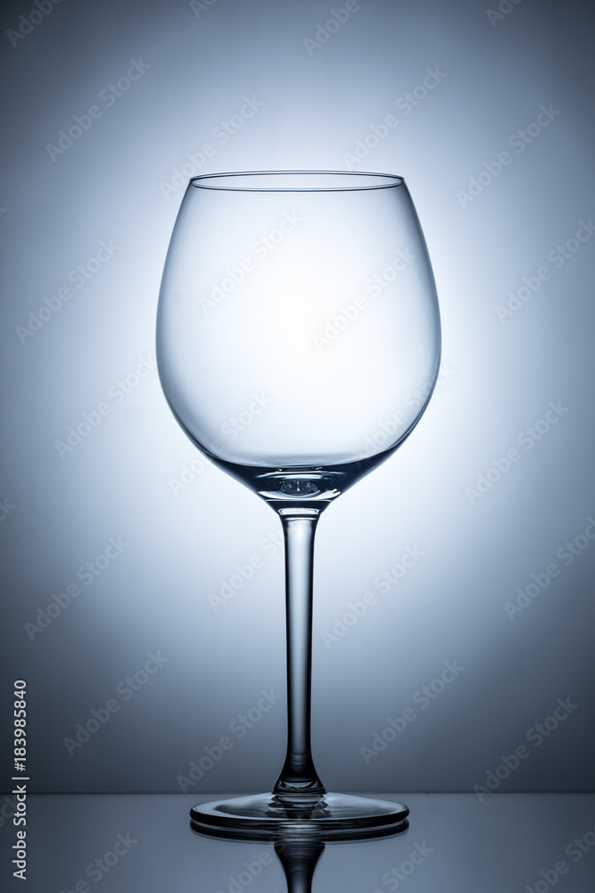 One empty wineglass for red wine on diffusion lit background One empty wineglass for red wine on diffusion lit background
