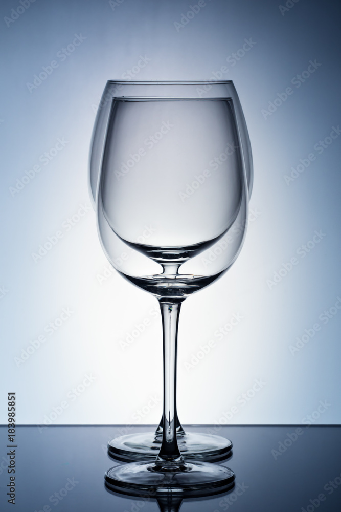 Two empty wineglass for red wine on diffusion lit background in abstract .. composition with reflection Two empty wineglass for red wine on diffusion lit background in abstract .. composition with reflection