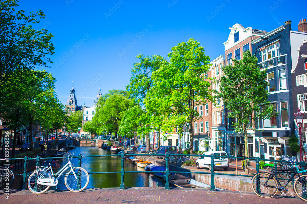 Beautiful canal and traditional bikes in old city of Amsterdam, Netherlands, North Holland province.