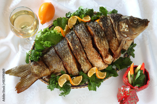 Fried fish-carp.Served in the plate entirely,decorated with greens with lemon and white wine.