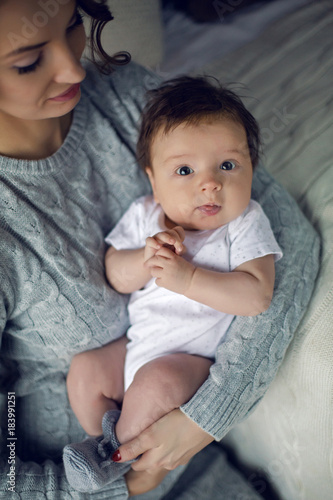 mom in a sweater holding in his hand his son's baby