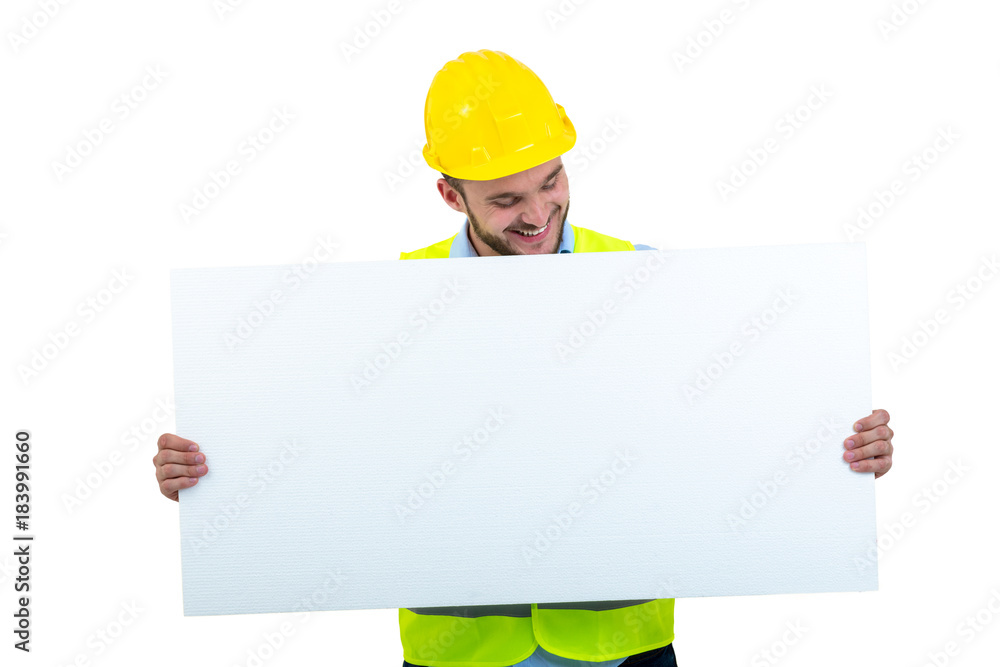 Happy male engineer holding an advertisement blank banner. Isolated on white background Happy male engineer holding an advertisement blank banner. Isolated on white background