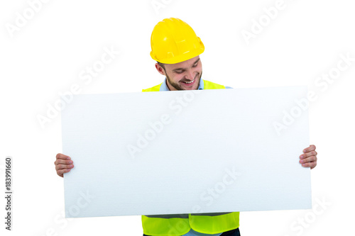 Happy male engineer holding an advertisement blank banner. Isolated on white background