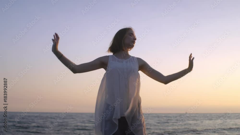 Young woman practicing plastic exercises on beach at sunset Young woman practicing plastic exercises on beach at sunset