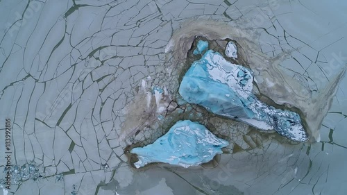 Aerial footage of blue iceberg in frozen lagoon, Fjallsárlón Iceland photo