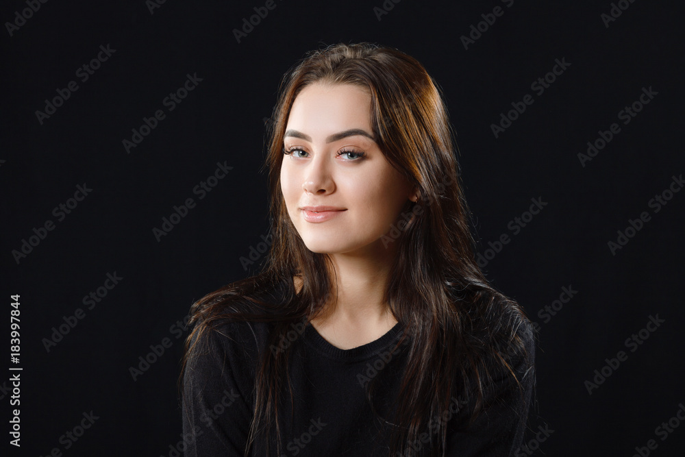 Low key portrait of young adorable caucasian woman in black sweater on dark background. Facial expressions and emotion concept. Low key portrait of young adorable caucasian woman in black sweater on dark background. Facial expressions and emotion concept.