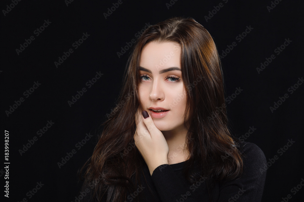 Low key portrait of young adorable caucasian woman in black sweater on dark background. Facial expressions and emotion concept. Low key portrait of young adorable caucasian woman in black sweater on dark background. Facial expressions and emotion concept.