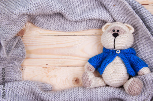 knitting teddy bear with vintage camera on a wooden background